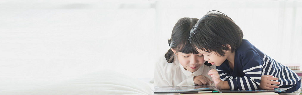 Cute children reading a book on white bed