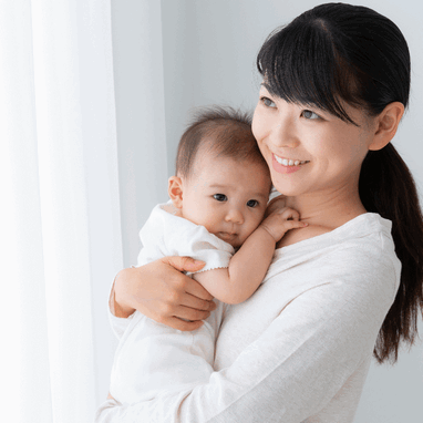 A mother looking at her happy, laughing baby which she is holding. A mother looking at her happy, laughing baby which she is holding.