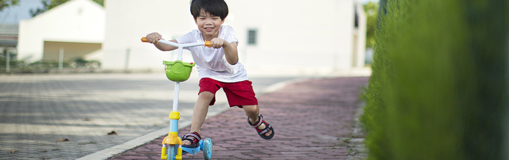 A young boy standing at the top of a set of stairs, smiling.