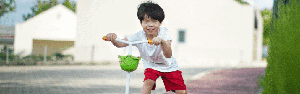 A young boy standing at the top of a set of stairs, smiling.