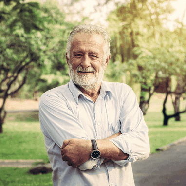 A middle aged, bespectacled man standing in his back yard.
