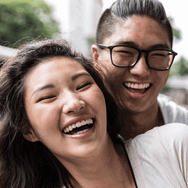 A young man and woman smiling for the camera in a suburban street. A young man and woman smiling for the camera in a suburban street.