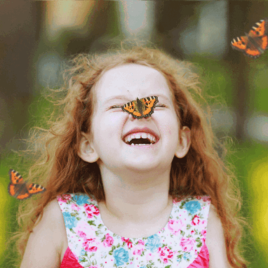 A little girl smiling and laughing at the breakfast table. A little girl smiling and laughing at the breakfast table.