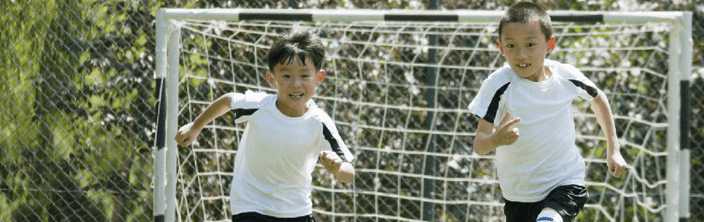 A young boy running happily through the street.