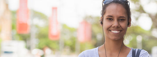 A young woman with her headphones in walking through the city. A young woman with her headphones in walking through the city.