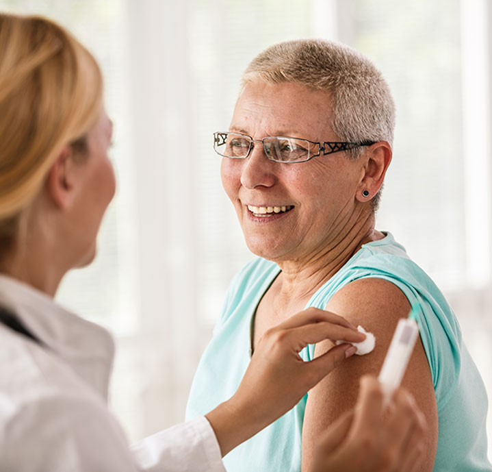 A nurse holding a cotton ball to a woman's arm after an injection
